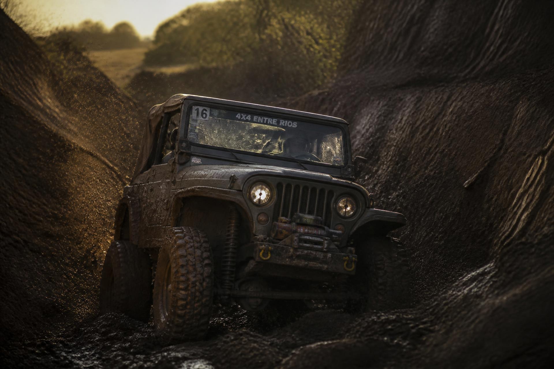 Jeep embarrado trepando una barranca de arcilla en La Cantera